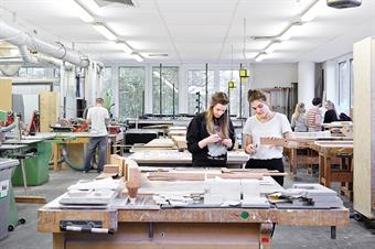 Dieses Bild zeigt drei Studenten in der Holzwerkstatt des Fachbereichs Architektur.